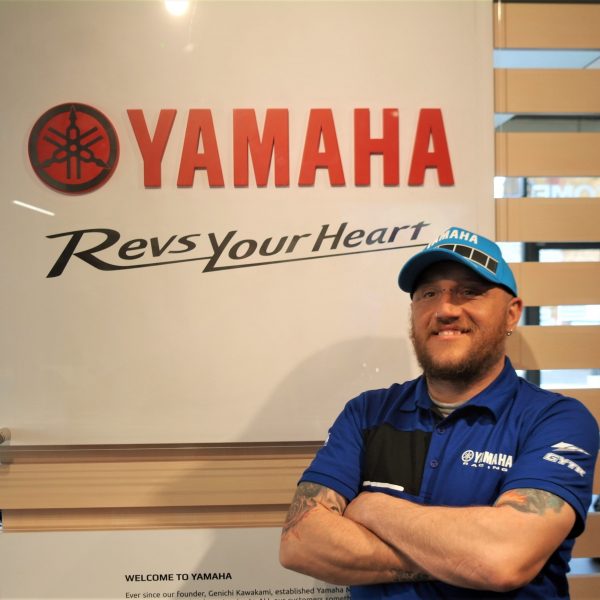 Man stood next to Yamaha logo Tim
